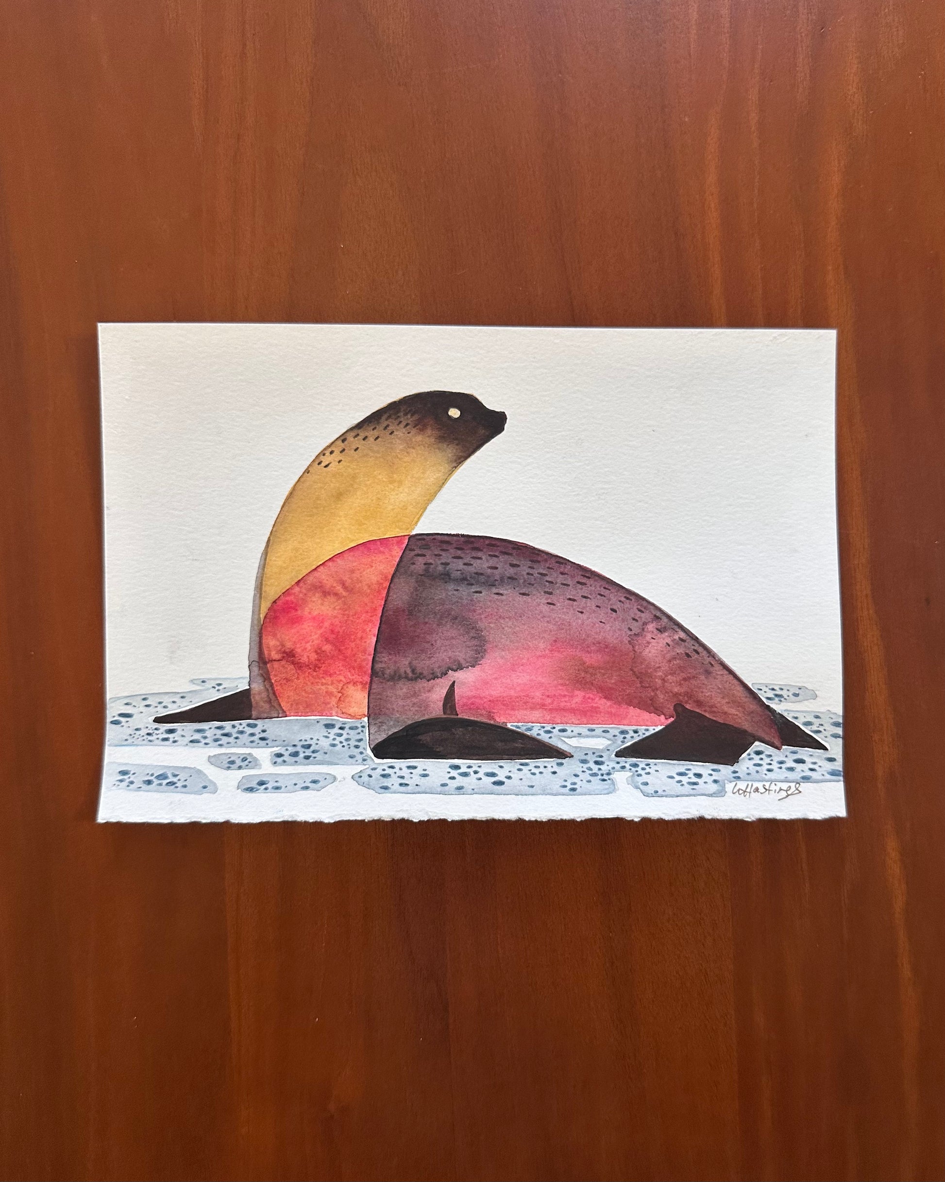 Colorful seal illustration on a white card with a wooden background